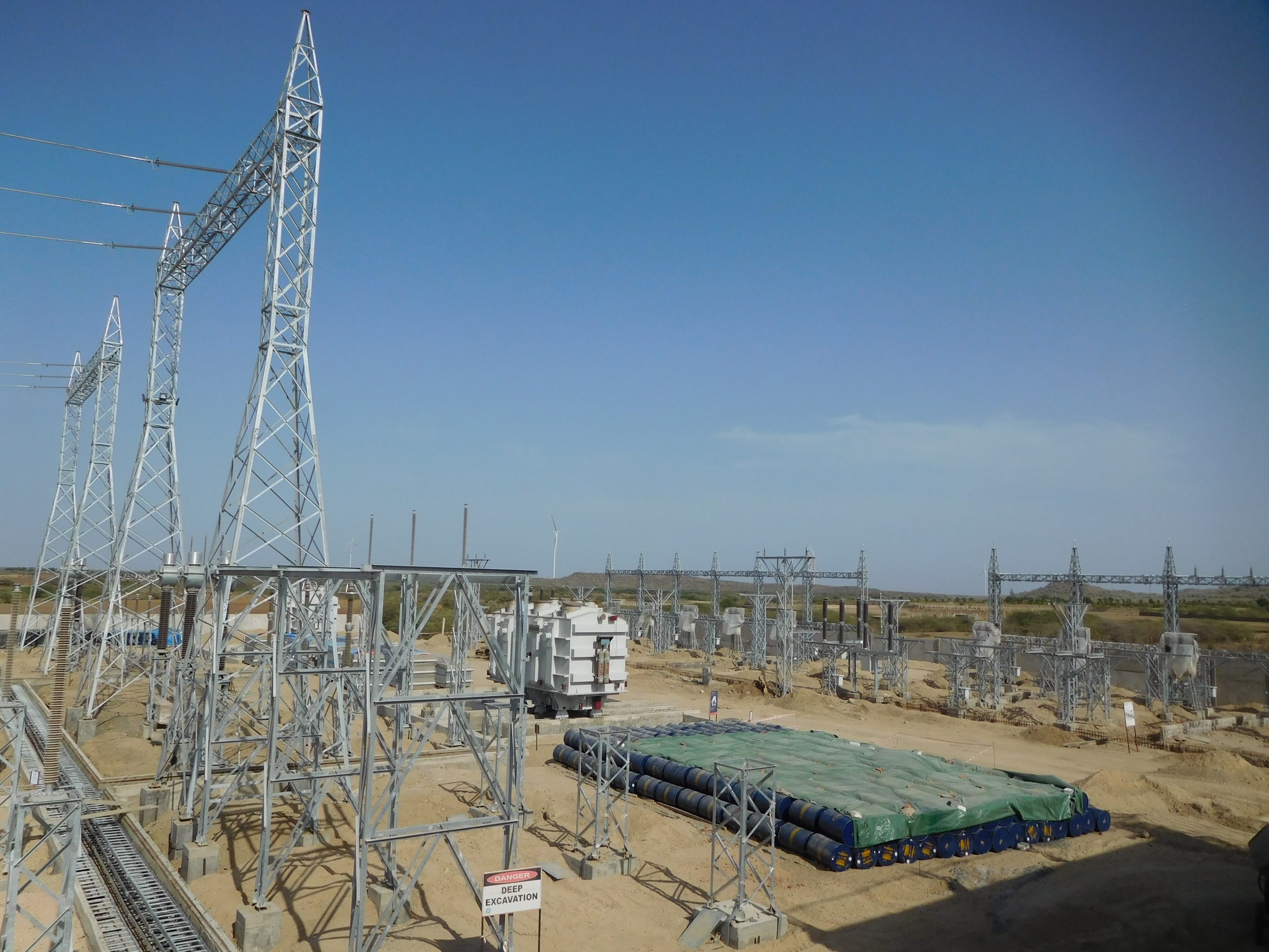 A large electrical substation with gantry structures and equipment for high-voltage power distribution.