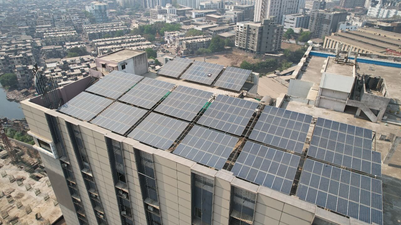 Close-up of solar PV panels on a Millennium Market skyscraper rooftop overlooking a dense cityscape