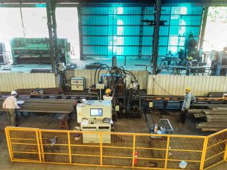 Overhead view of CNC bending and shearing machines with operators in background